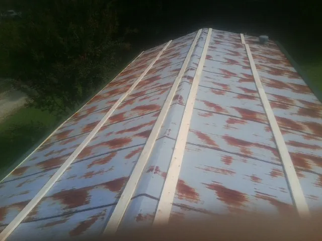 Rusted metal roof panels with new wood purlins before replacement — Storm Damage Roof Repair in New Century by Roofing Brothers