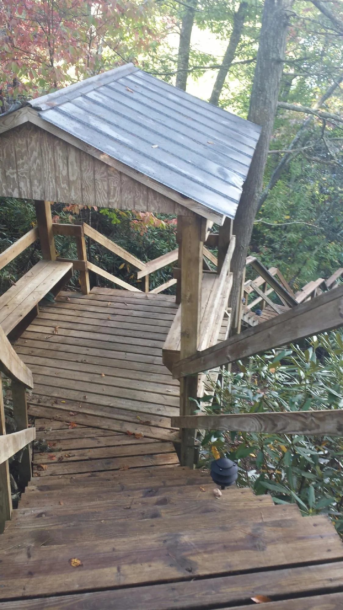 Metal roofed shelter over wooden steps on a wooded walkway — Skylight Repair & Installation work by our crew in New Century