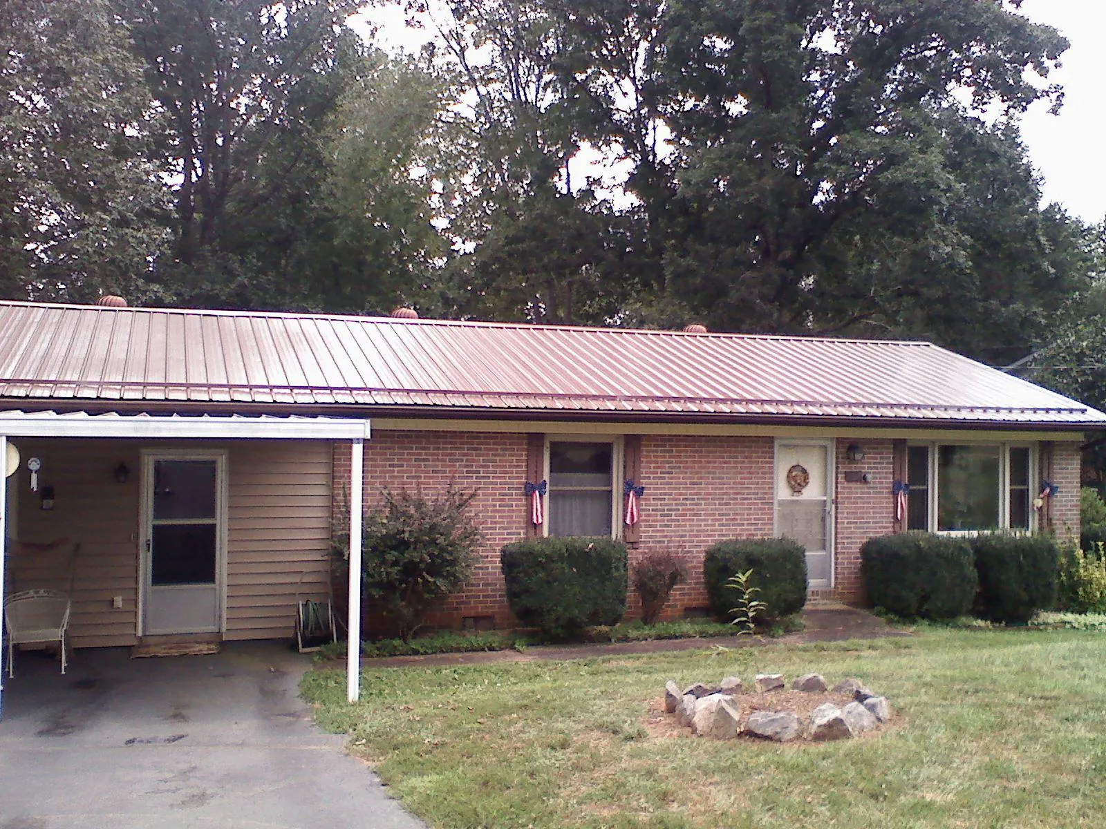 Bronze metal roof and carport on a brick ranch home — Roof Repair work by our crew in New Century