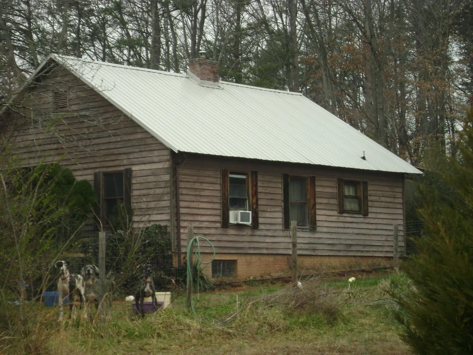 White metal roof on an old wood sided farmhouse, from a Metal Roof Installation job in New Century